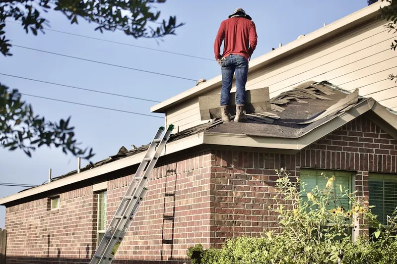 Professional roofer working on a residential roof in Waterbury